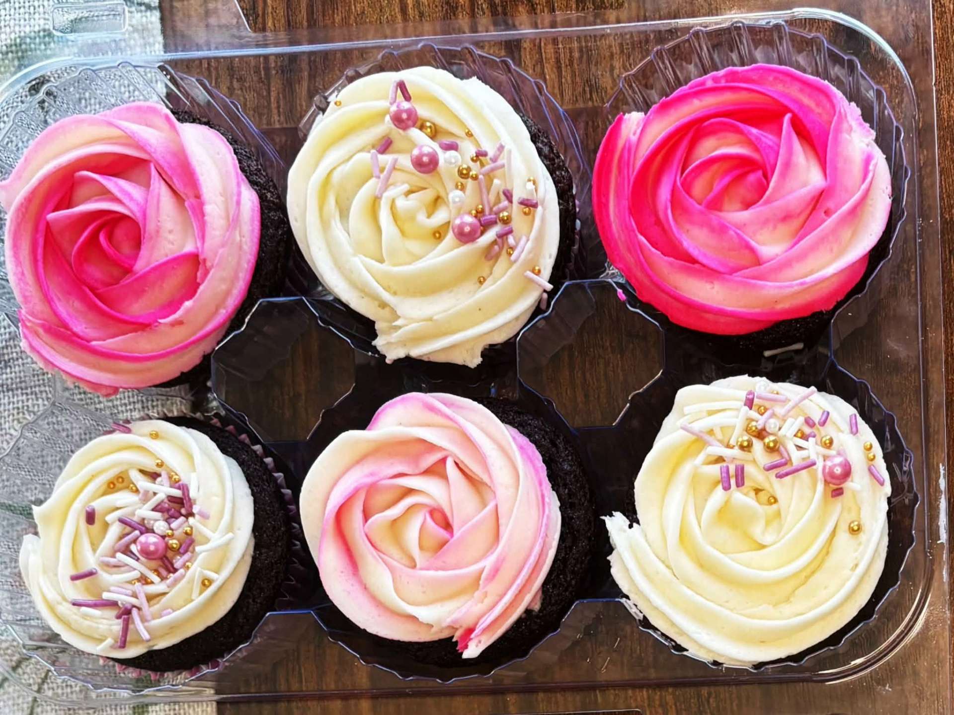 Chocolate cupcakes with pink rosettes and pearl sprinkles