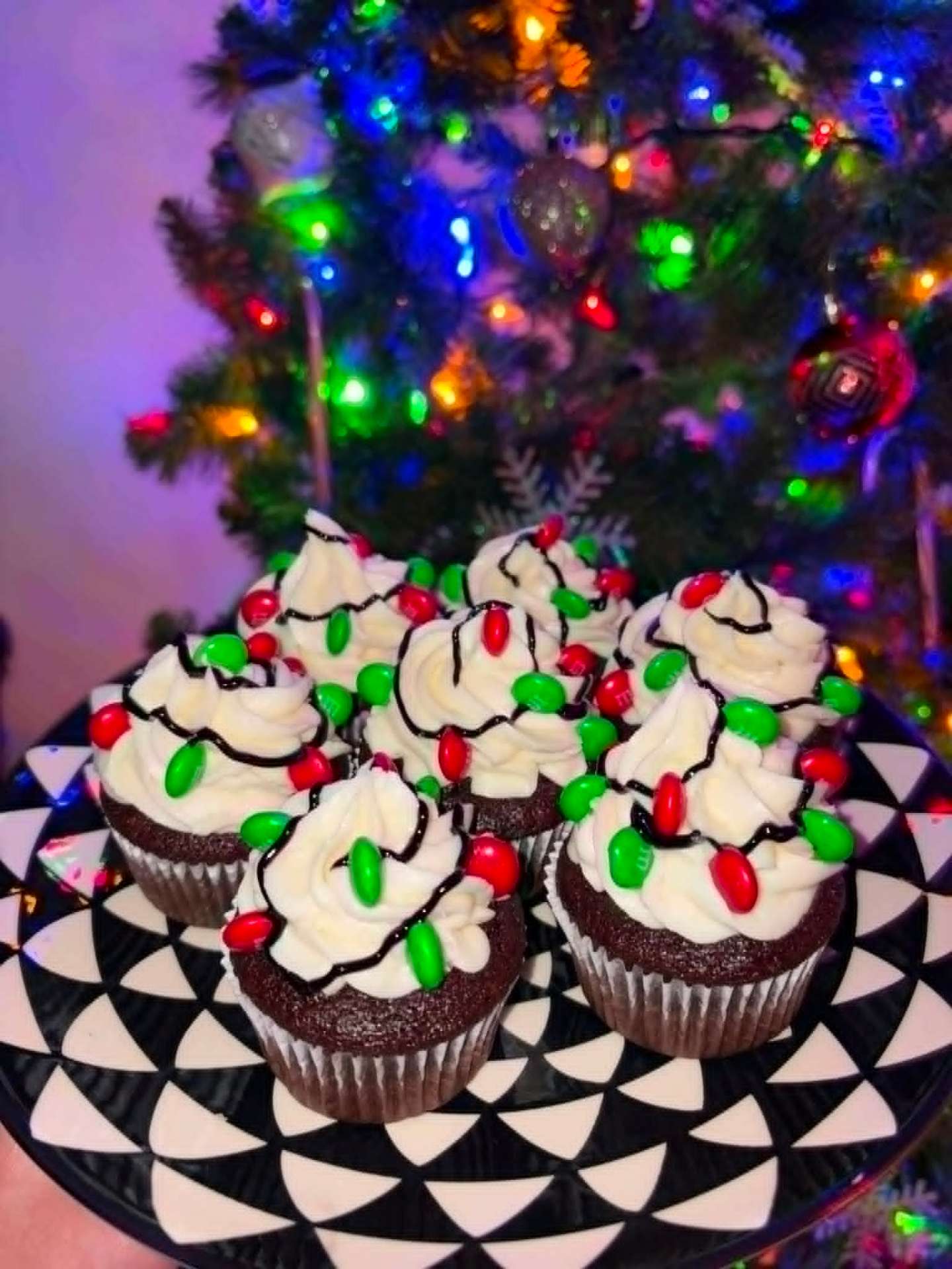 Chocolate cupcakes decorated like Christmas lights by the tree